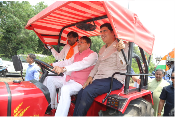 मुख्यमंत्री धामी ने जब पारंपरिक मंच से उतरकर ट्रैक्टर की स्टेयरिंग संभाली, तो सड़क पर उत्साह की लहर दौड़ गई।